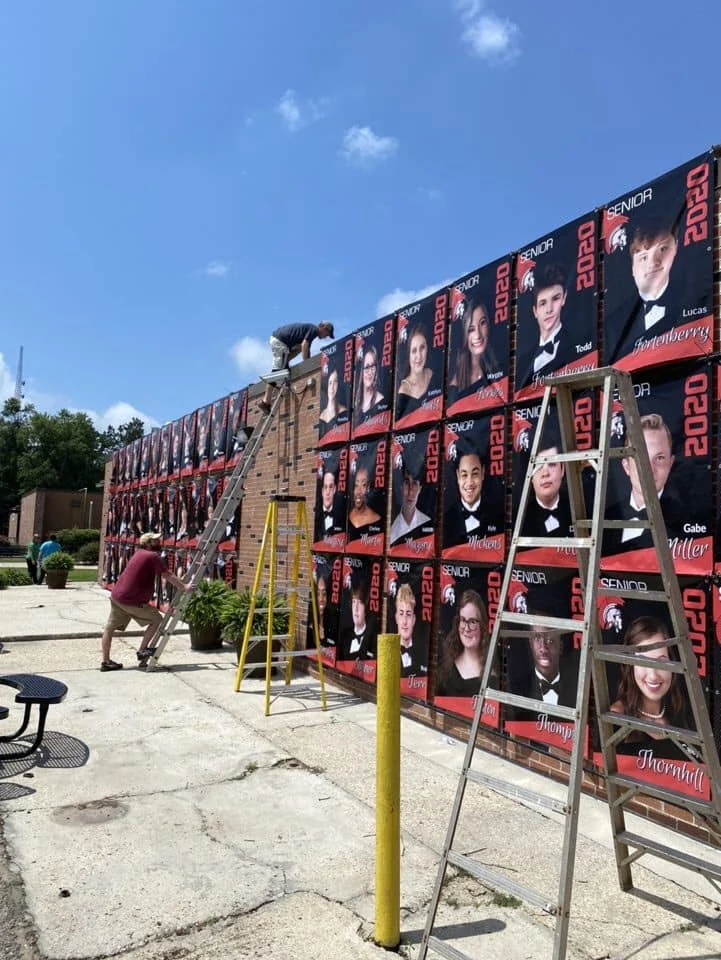 Large event graphics being installed with ladders